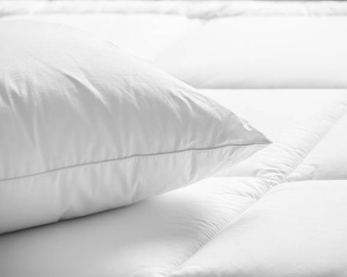 Closeup of white pillow on the bed in the bedroom